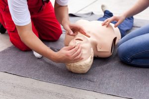 2 practising CPR on a manikin for an annual CPR refresher course.